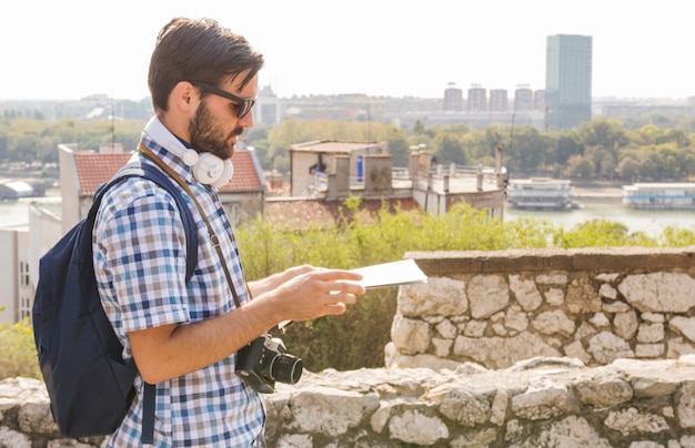 Foto gratuita vista lateral de un excursionista hombre mirando el mapa