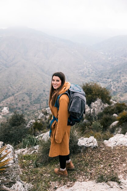 Vista lateral de un excursionista con su mochila de senderismo en las montañas