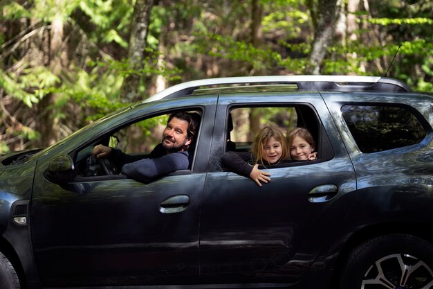 Vista lateral familia viajando en coche.