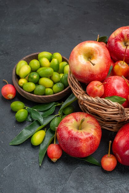 Vista lateral frutas cítricos cesta de madera de cerezas y manzanas