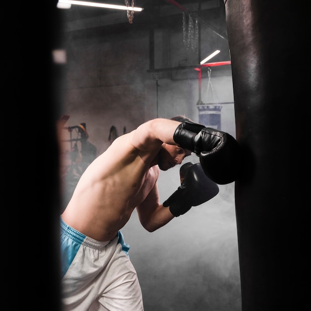 Vista lateral fuerte entrenamiento de boxeador masculino para una competencia