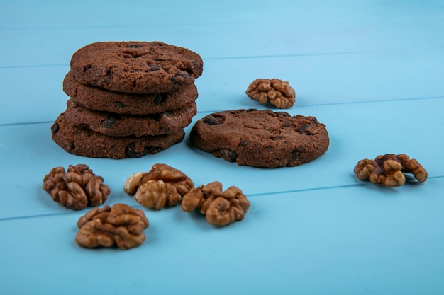 Foto gratuita vista lateral de galletas de brownie de mantequilla de maní sin harina y nueces sobre fondo azul.