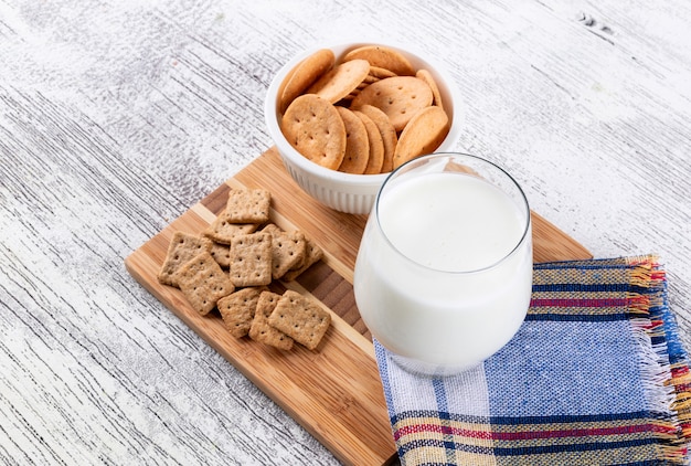 Vista lateral de galletas con leche en tablero de madera horizontal