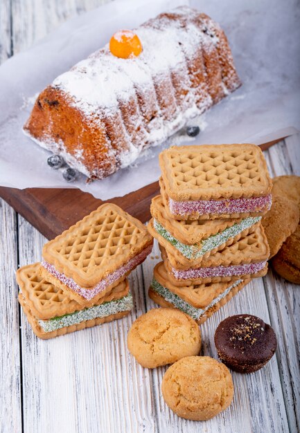 Vista lateral de galletas con mermelada de bayas rellenas en rústico