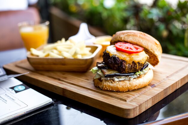 Vista lateral hamburguesa de carne con papas fritas