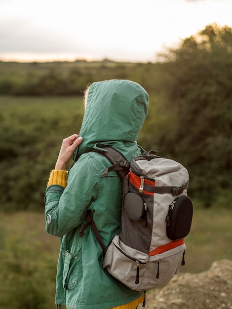 Foto gratuita vista lateral hembra con mochila al atardecer