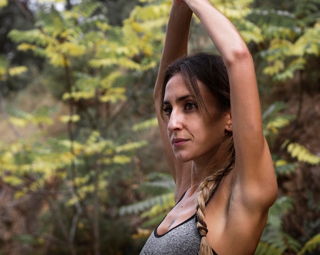 Foto gratuita vista lateral de la hermosa mujer haciendo yoga en la naturaleza