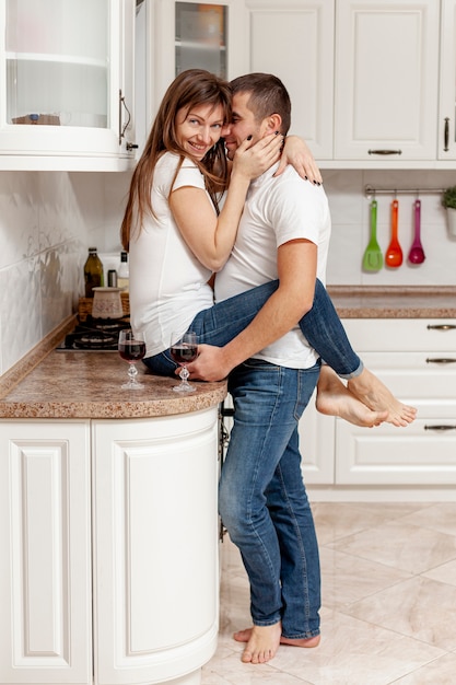 Foto gratuita vista lateral hombre abrazando a su novia en la cocina