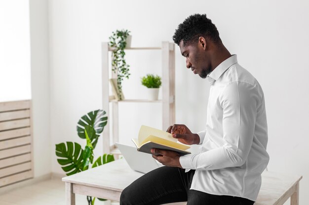 Vista lateral, hombre americano africano, lectura