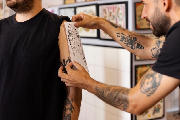 Vista lateral hombre colocando tatuaje