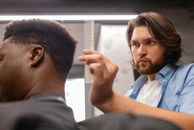 Foto gratuita vista lateral del hombre cortándose el pelo