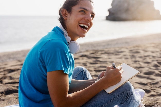 Foto gratuita vista lateral hombre escribiendo en cuaderno