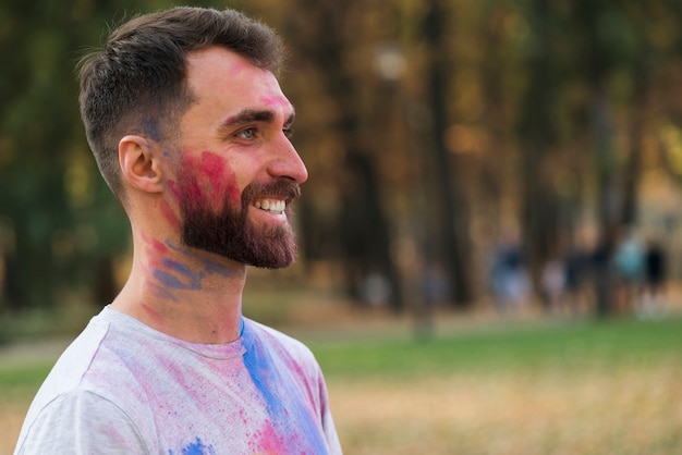 Vista lateral del hombre feliz en el festival holi