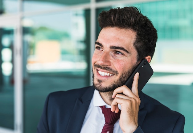 Vista lateral hombre feliz con su teléfono inteligente