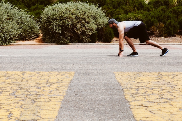 Vista lateral de un hombre en forma listo para correr