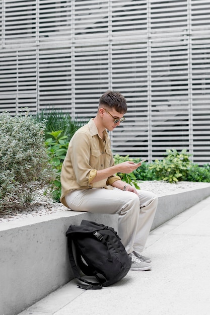 Foto gratuita vista lateral del hombre con gafas de sol y mochila al aire libre