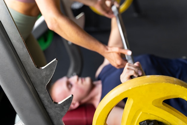 Vista lateral hombre haciendo ejercicio en el gimnasio