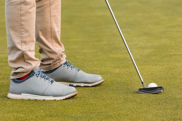 Foto gratuita vista lateral del hombre jugando al golf con palo y pelota