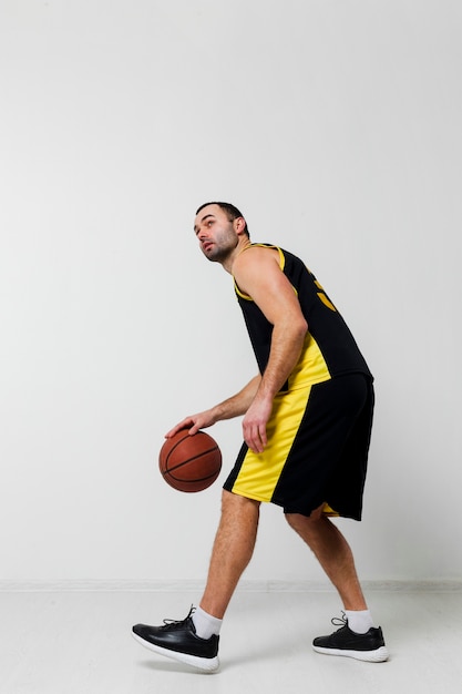 Foto gratuita vista lateral del hombre jugando baloncesto con espacio de copia