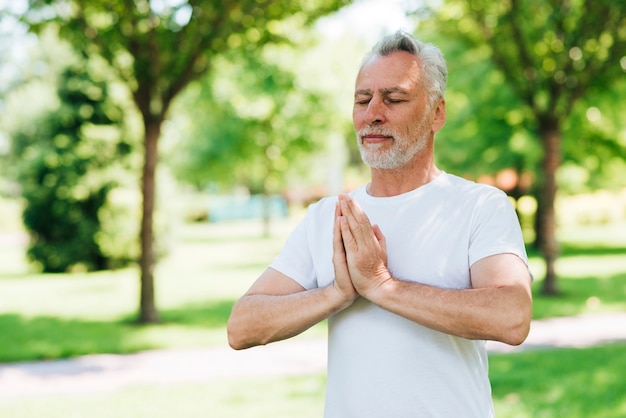 Vista lateral del hombre con las manos en posición de meditación