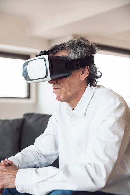 Vista lateral del hombre mayor que usa un casco de realidad virtual