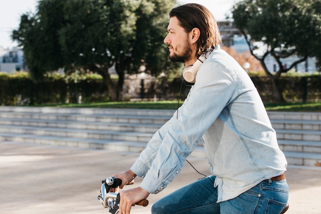 Foto gratuita vista lateral de un hombre montando bicicleta en el parque