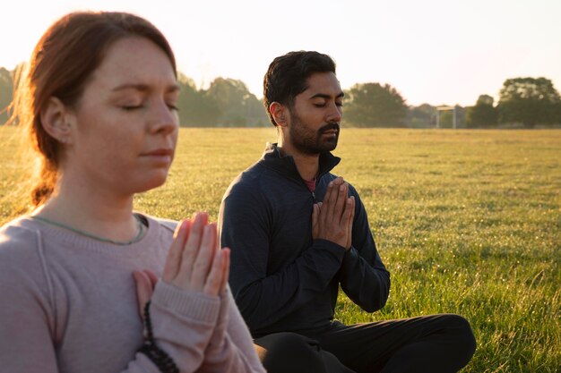 Vista lateral, de, hombre y mujer, meditar, aire libre