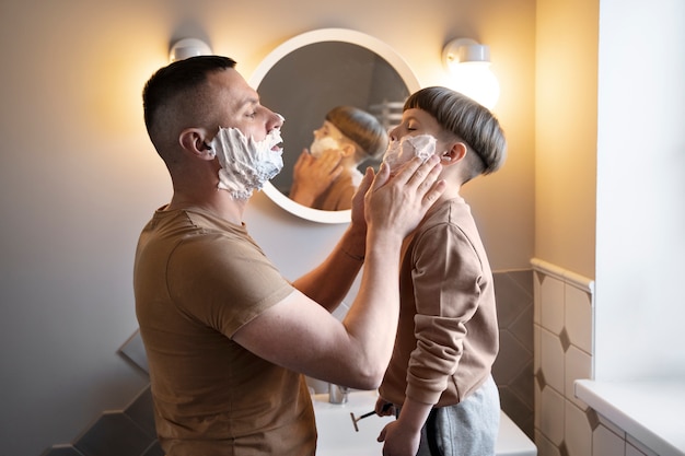 Vista lateral hombre y niño con crema de afeitar