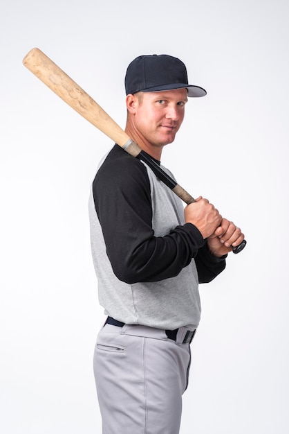 Vista lateral del hombre posando con bate de béisbol