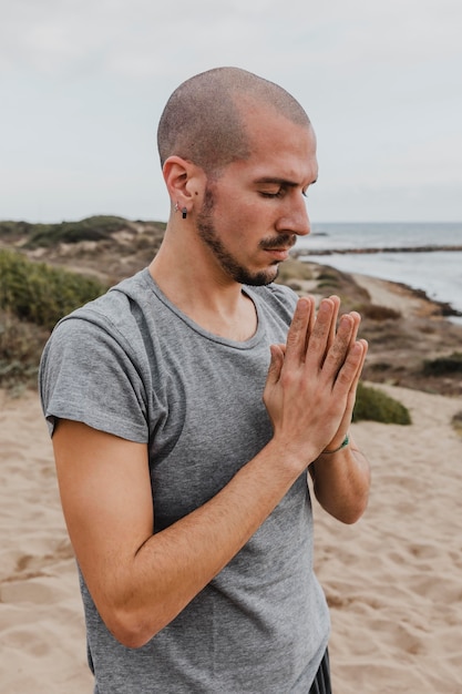 Vista lateral del hombre en posición de meditación al aire libre