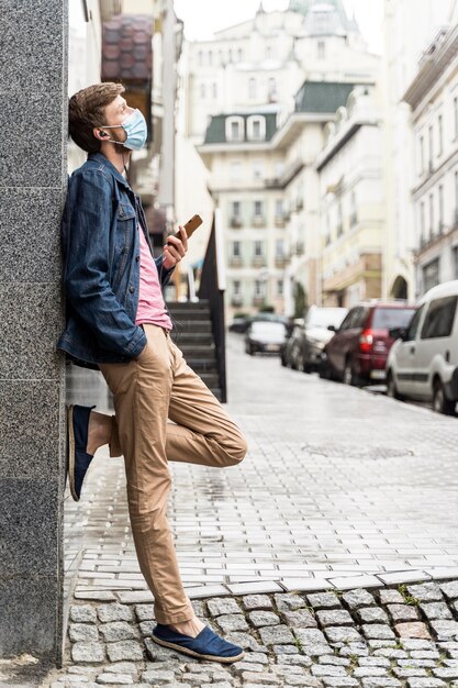 Vista lateral del hombre que llevaba una máscara médica fuera