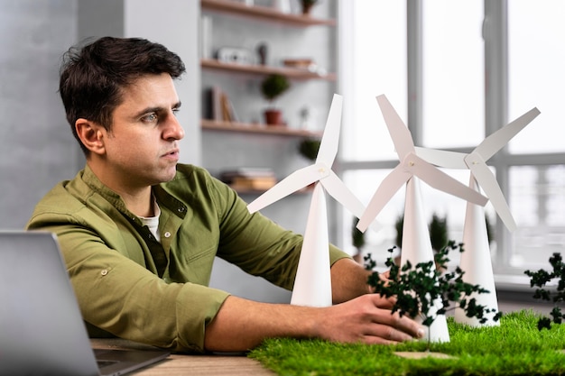 Vista lateral del hombre que trabaja en un proyecto de energía eólica ecológica