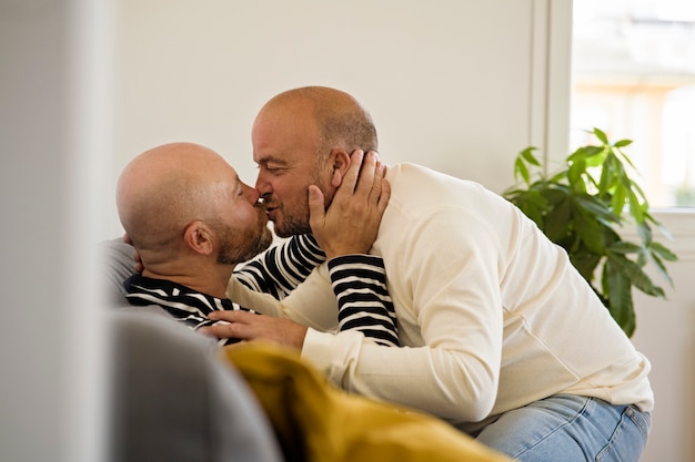 Foto gratuita vista lateral hombre queer besándose en casa