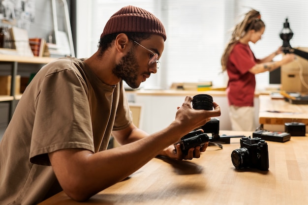 Foto gratuita vista lateral hombre reparando cámara de fotos