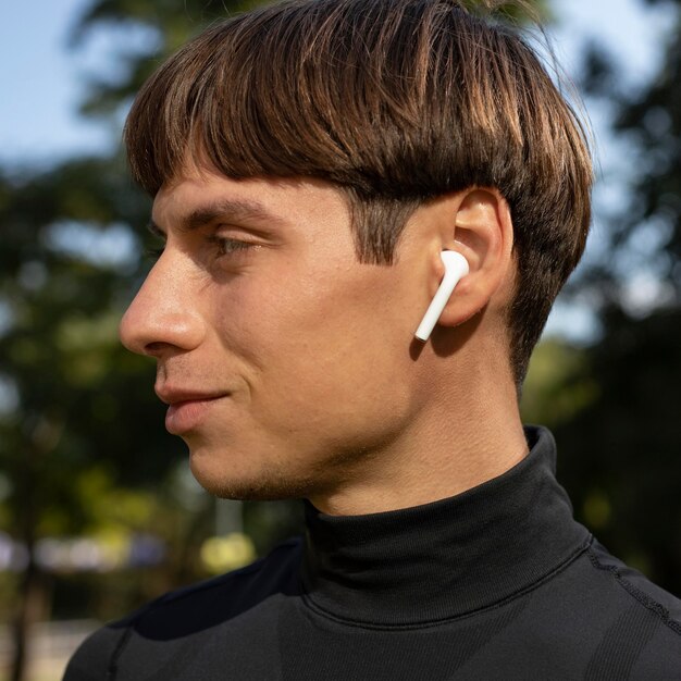 Vista lateral del hombre en ropa deportiva y auriculares al aire libre