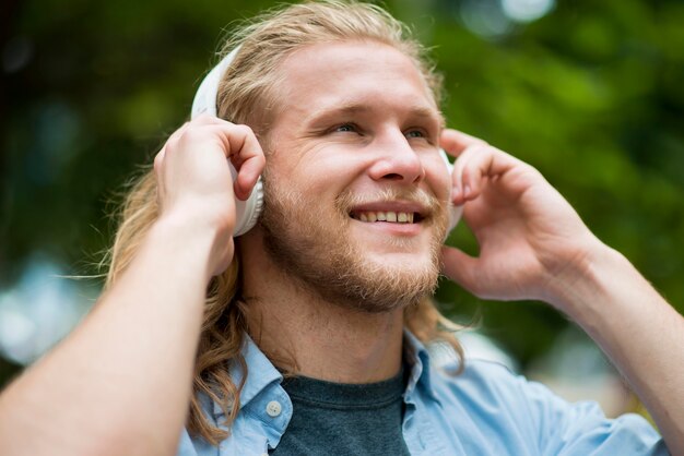 Vista lateral del hombre sonriente con auriculares