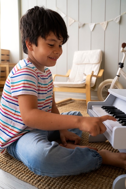 Vista lateral hombre sonriente con piano pequeño