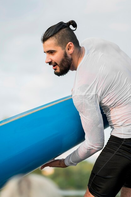 Vista lateral hombre sosteniendo kayak