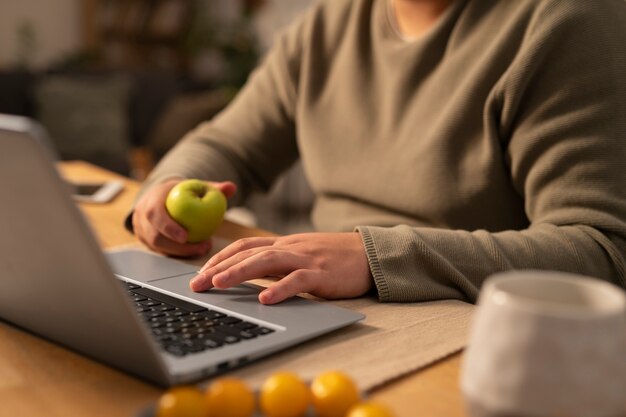 Vista lateral de un hombre de talla grande que trabaja en una computadora portátil