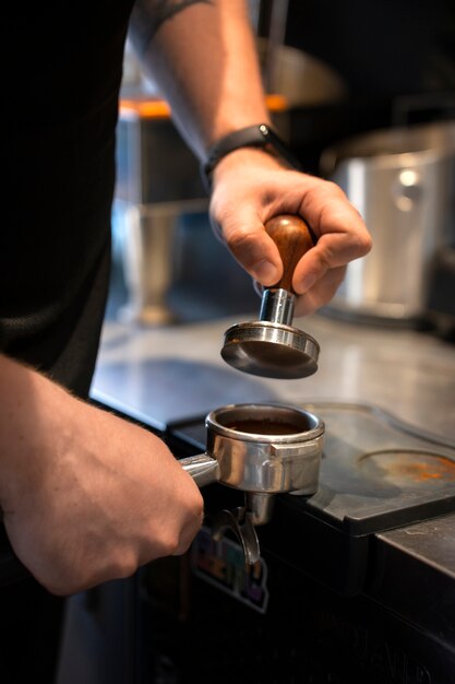 Vista lateral de un hombre de talla grande trabajando como barista