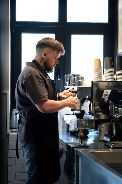 Vista lateral de un hombre de talla grande trabajando como barista