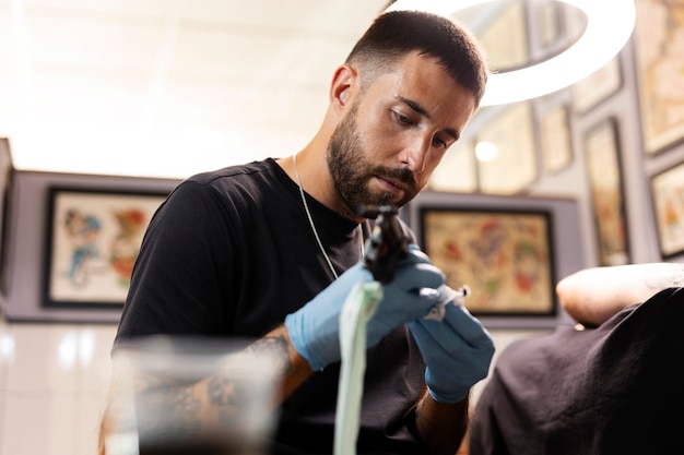 Foto gratuita vista lateral hombre tatuando con guantes