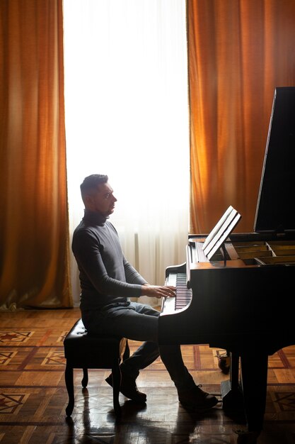Vista lateral hombre tocando el piano