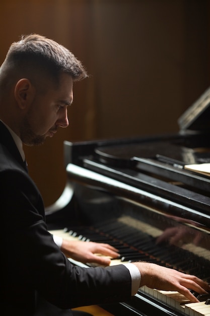 Foto gratuita vista lateral hombre tocando el piano