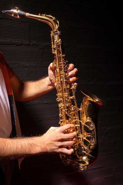 Vista lateral del hombre tocando el saxofón