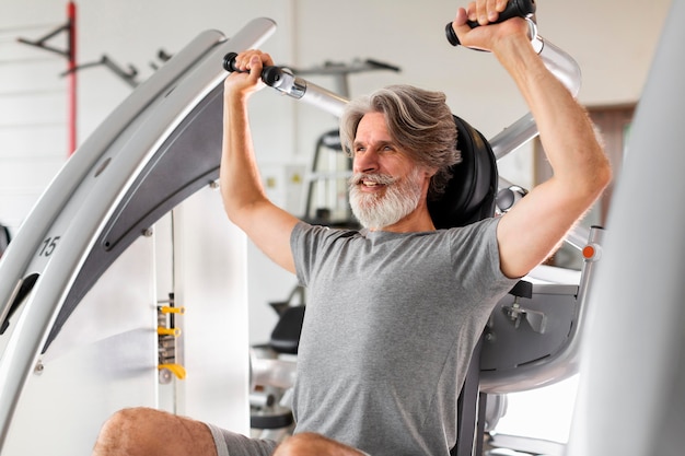 Foto gratuita vista lateral hombre trabajando en el gimnasio