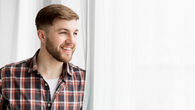 Foto gratuita vista lateral del hombre en la ventana con espacio de copia