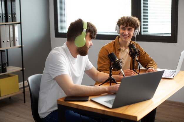 Vista lateral de hombres grabando podcast amigable