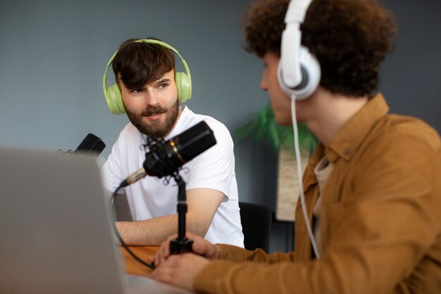 Vista lateral de hombres grabando podcast