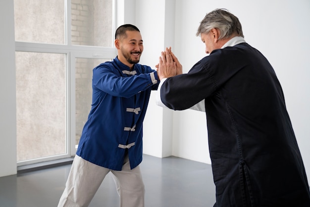 Foto gratuita vista lateral hombres practicando tai chi juntos